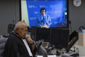 Former Philippine President Rodrigo Duterte is seen on a screen with his lawyer Salvador Medialdea (L) in the courtroom during his first appearance before the International Criminal Court (ICC) on charge of crimes against humanity over his deadly crackdown on narcotics, in The Hague on March 14, 2025.