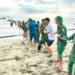 Lực lượng chức năng và người dân cứu hộ tàu thuyền bị sóng đánh chìm trên biển - Ảnh: H.A.