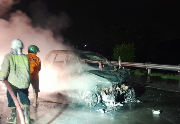 Sebuah mobil minibus Toyota Avanza dengan nomor polisi N 1478 ABN terbakar hebat usai terseret truk sejauh 200 meter. Foto iNewsSurabaya/aries