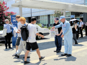 飲料を無料配布するキリンビール横浜工場長（右）（キリンビール横浜工場提供）
