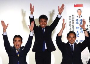 当選を確実にし、支援者らと万歳する籠島氏（中央）＝２０日午後８時１０分ごろ、横浜市西区の会議室3