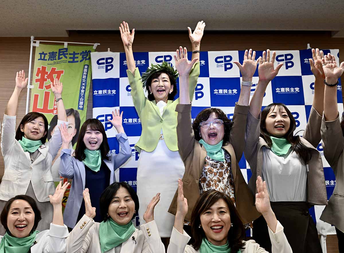 ４期目の当選を確実にし、万歳する牧山氏（中央）ら＝２０日午後８時１０分ごろ、横浜市中区のホテル（立石 祐志写す）