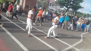 Atlet muda olahraga tarung derajat membuat pengunjung car free day (CFD) Depok berdecak kagum. Keramaian jalan Raya Margonda di kala CFD tidak mengurangi performa latihan para petarung derajat. Foto: Averus Al Akutsar/detikHealth