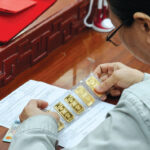 A customer buys SJC-brand gold bars in HCMC - PHOTO: LE VU