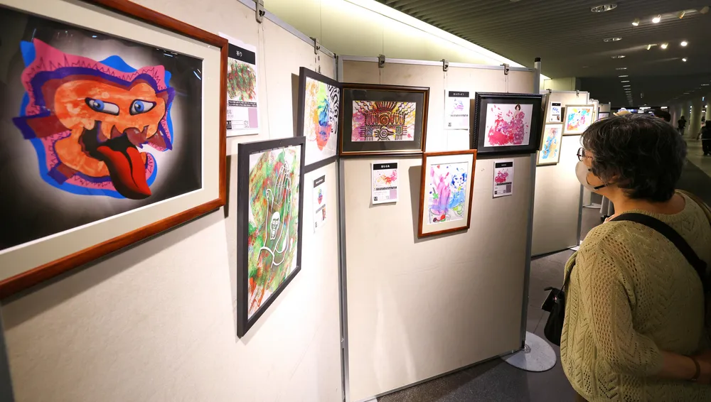 障害のある子どもたちと共同製作した作品が並ぶ絵画展（井上浩明撮影）