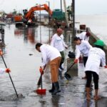 COMMUNITY EFFORT. Residents of Baseco Compound, armed with protective gears such as boots and gloves, join a cleanup drive amid flooding in Tondo, Manila in this September 2024 file photo. The Department of the Interior and Local Government encourages communities to clean their surrounding as mandated by the KALINISAN (Kalinga at Inisyatiba para sa Malinis na Bayan) program. (PNA photo by Yancy Lim)