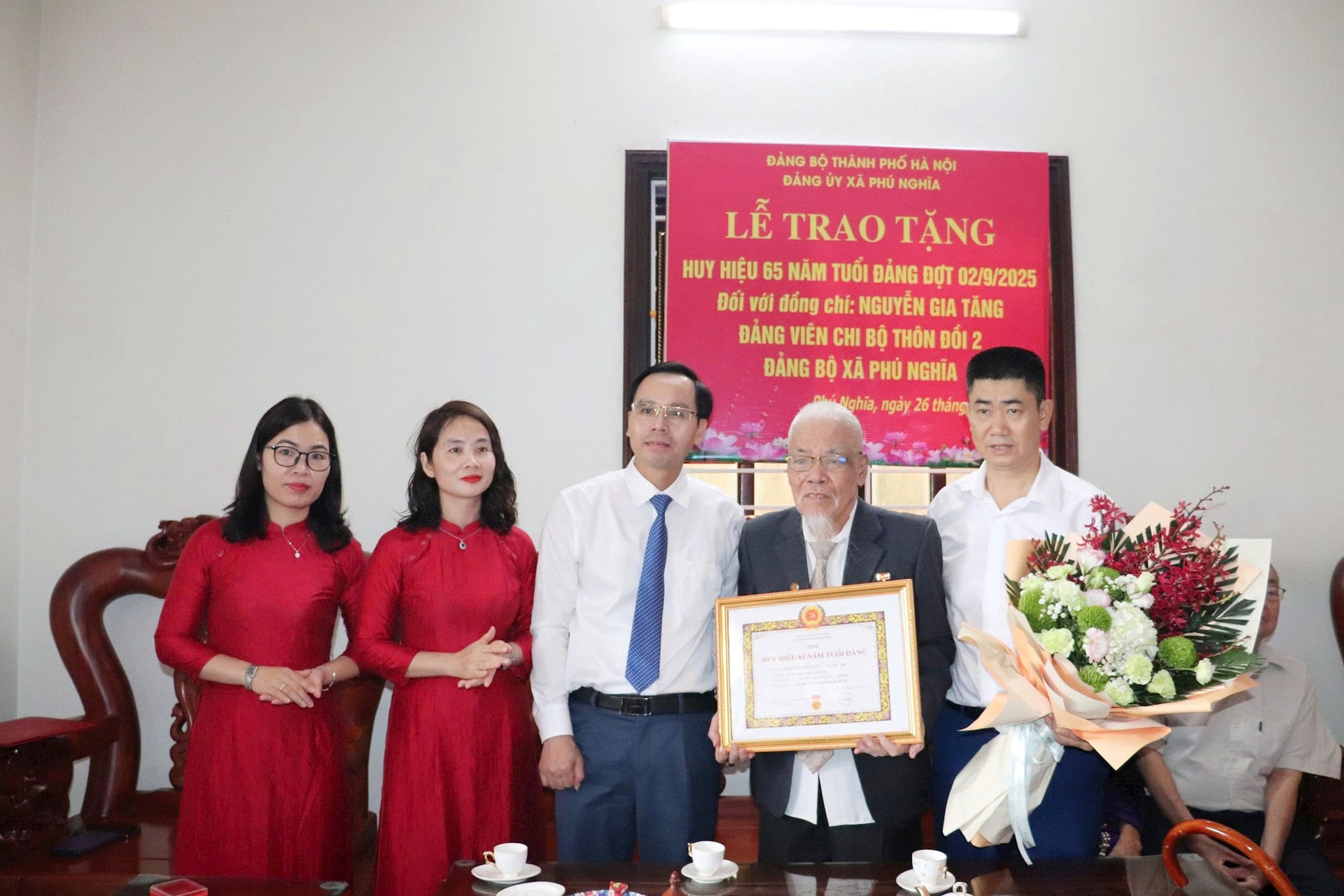 Bí thư Đảng ủy, Chủ tịch HĐND xã Phú Nghĩa Trịnh Tiến Tường trao Huy hiệu 65 năm tuổi Đảng tặng đồng chí Nguyễn Gia Tăng. Ảnh: Kim Thoa