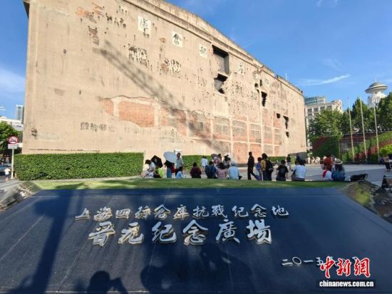 8月7日，在上海四行仓库抗战纪念地晋元纪念广场，民众仰望弹痕累累的四行仓库西墙。 范宇斌 摄