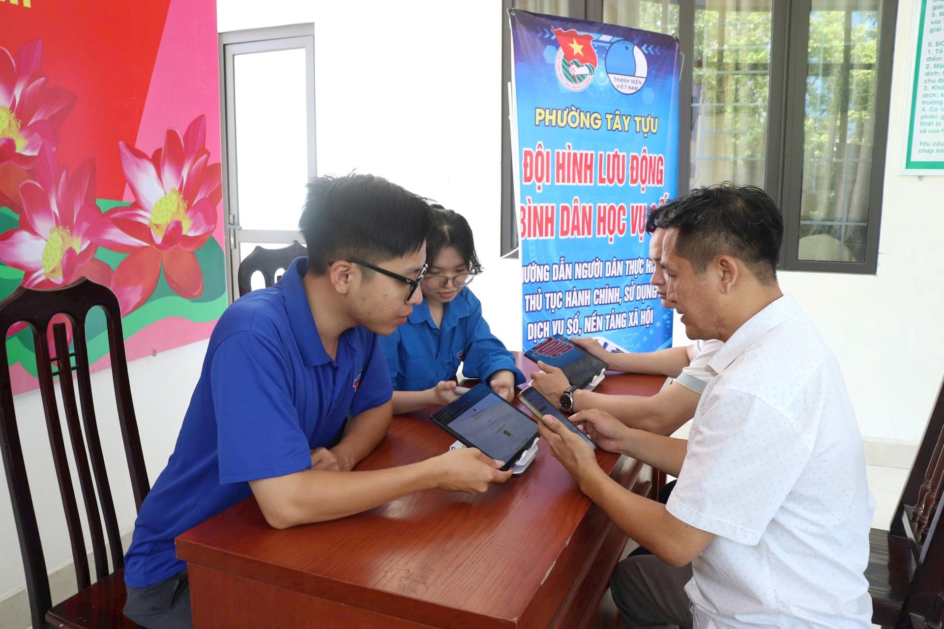 Members of Tay Tuu Ward's community digital transformation group guide residents in using digital applications.