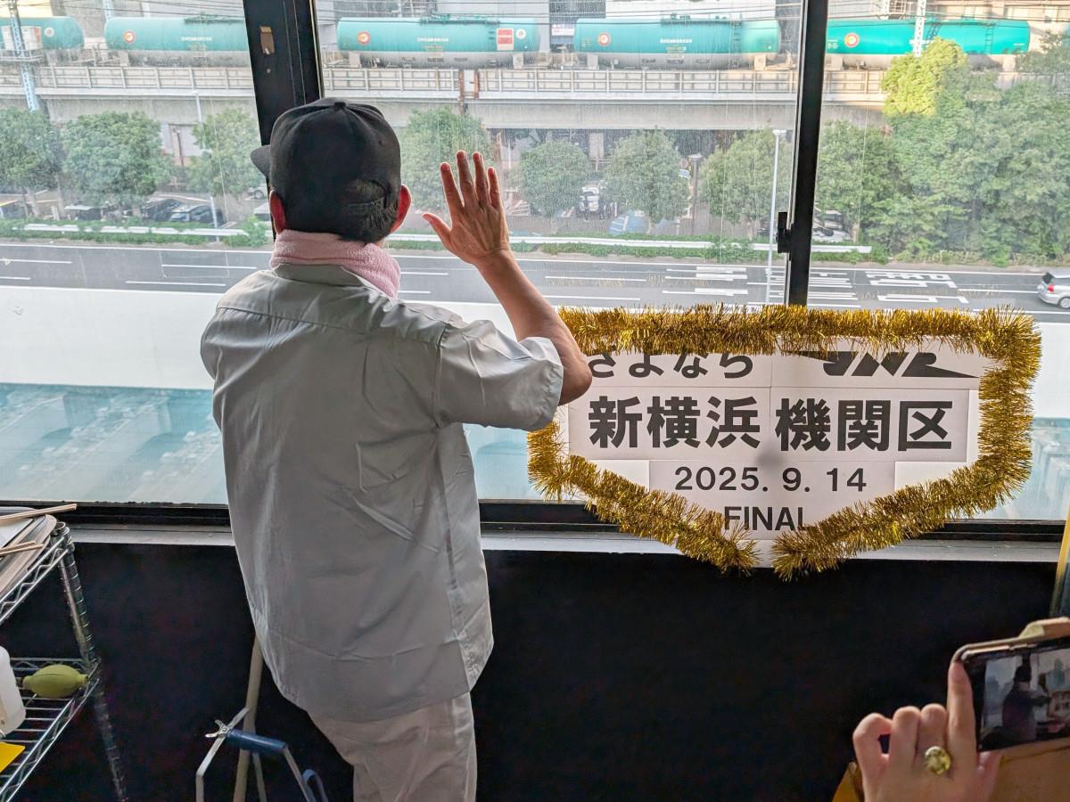Hanashima Nobuyuki looking out the window at the Shin-Yokohama Kikanshu. The JR Negishi Line freight trains visible from inside the shop were the deciding factor for opening the store here.