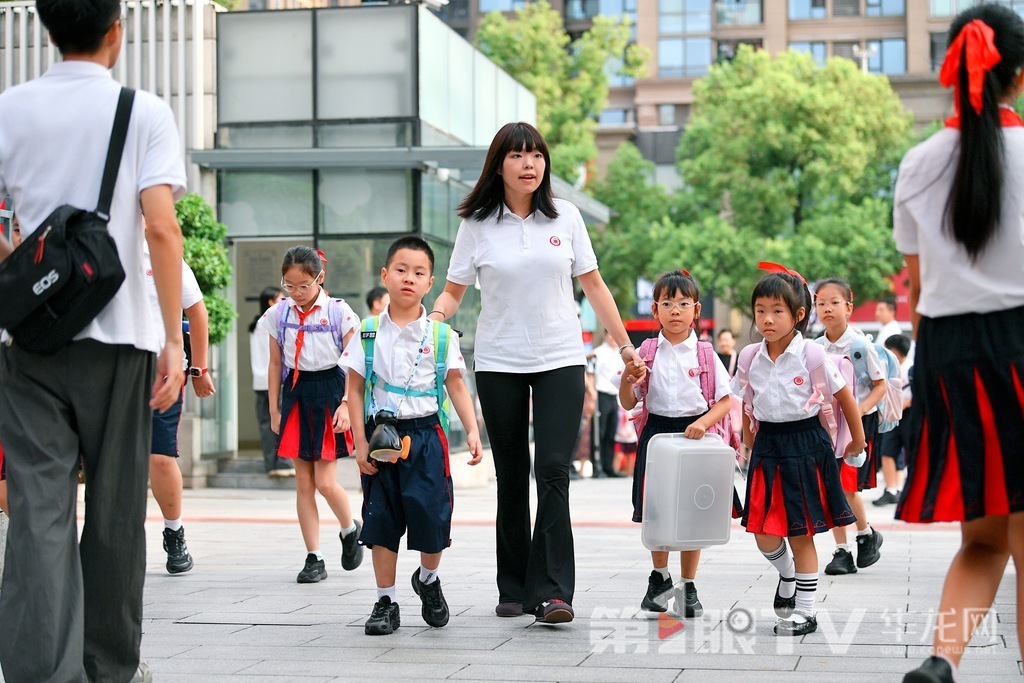At Chongqing Xie Jia Wan School, a teacher leads students into the classroom.