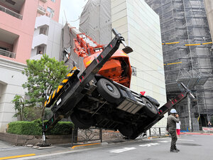 Grúa volqueta se desploma e impacta edificio de apartamentos en Bunkyo, Tokio.