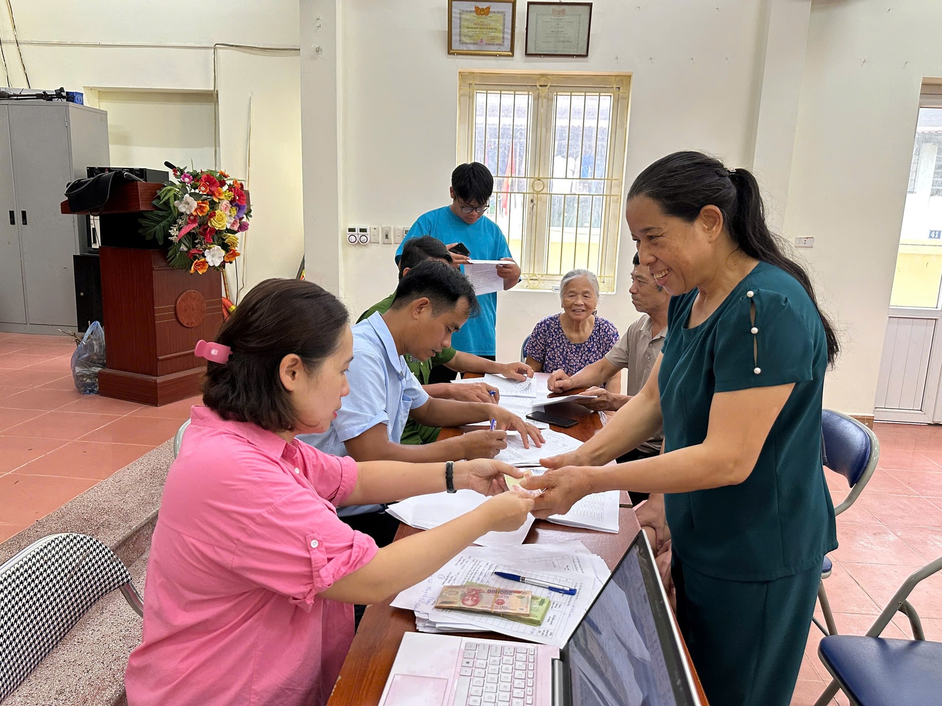 Người dân xã Bát Tràng phấn khởi nhận tiền Tết Độc lập. Ảnh: Phương Lộc