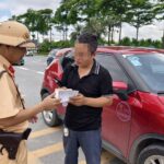 Lực lượng Cảnh sát giao thông xử lý trường hợp dừng, đỗ xe sai quy định tại khu vực ngoài Triển lãm. Ảnh: NT