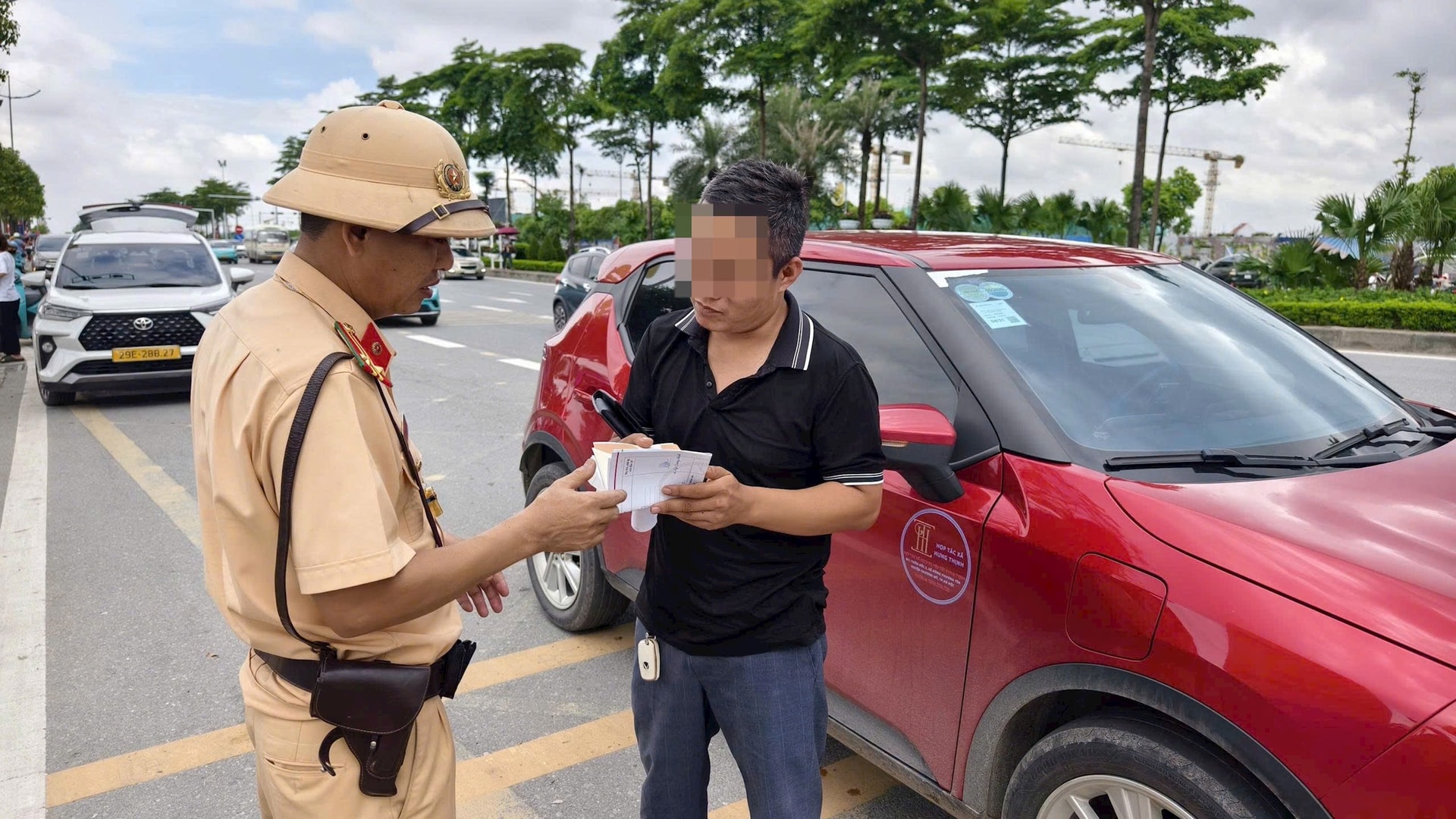 Lực lượng Cảnh sát giao thông xử lý trường hợp dừng, đỗ xe sai quy định tại khu vực ngoài Triển lãm. Ảnh: NT