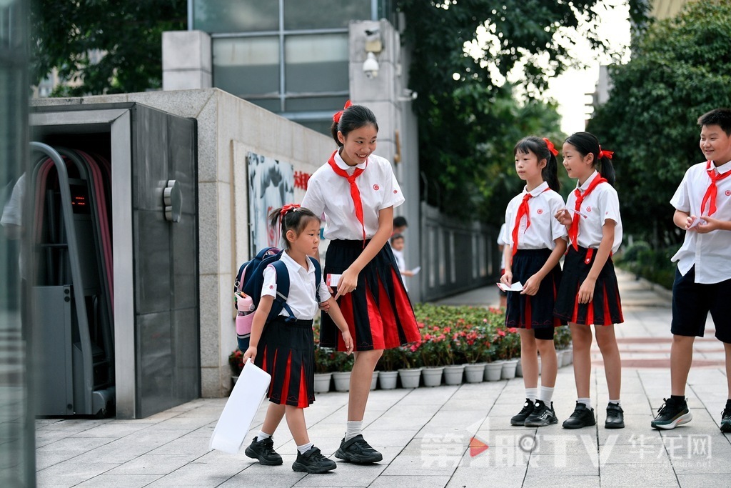 At Chongqing Xie Jia Wan School, older students lead younger ones into the school.