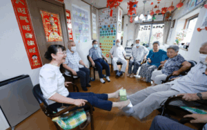 DAY CARE. At Isshoen, a day care facility in Tokorozawa, Saitama Prefecture, serving Japanese war orphans left behind in China, Mariko Kamijo (far left), the eldest daughter of a Japanese war orphan, participates in light exercises with clients on July 2.. (Jiji Press photo)