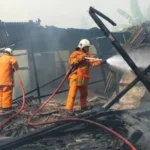 Petugas Pemadam Kebakaran dan Penyelamatan Kota Surabaya sedang memadamkan api di warung kopi Jalan Wonorejo Timur. Foto: Istimewa