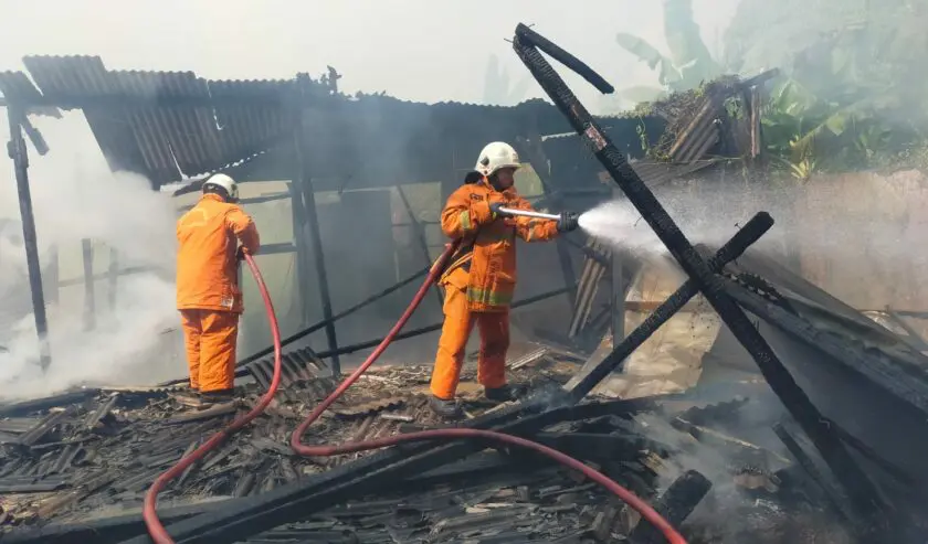 Petugas Pemadam Kebakaran dan Penyelamatan Kota Surabaya sedang memadamkan api di warung kopi Jalan Wonorejo Timur. Foto: Istimewa