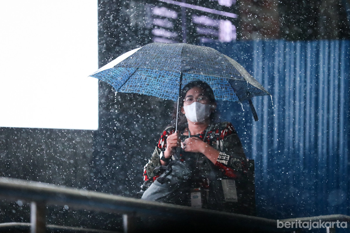 Residents amidst rain soaking the Jakarta area