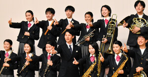 部のモットーは「心はひとつ」。演奏後、人さし指を立ててポーズをとり、顧問の上野和久教諭と写真撮影する３年生の部員ら=2025年10月18日午前9時21分、宇都宮市文化会館、石川瀬里撮影