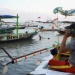 Nelayan Muncar, Banyuwangi tengah berkomunikasi menggunakan smartphone ditengah kesibukannya mencari ikan.