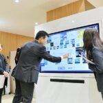 体験型コンテンツを体感する渡辺頭取（中央）＝８日、相模原市中央区