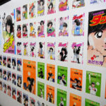 歴代作品のコミックス表紙が壁一面に広がる=2025年12月18日午後4時10分、東京都豊島区東池袋3丁目、立岩穣一撮影