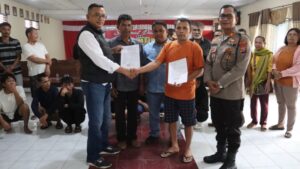 Perwakilan warga Desa Parbuluan VI dan pihak PT Gruti berjabat tangan usai menandatangani kesepakatan damai melalui jalur restorative justice yang difasilitasi Polres Dairi di Sidikalang, Jumat (9/1/2026).