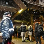 氷点下9度の寒さの中、北海道神宮で参拝客の雑踏事故の警戒にあたる札幌西署地域課の中山夢叶巡査。制服には雪が降り積もっていた＝1日午前0時30分、札幌市中央区（樋口史典撮影）