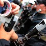 PNP officers submit their service firearms for taping. File photo
