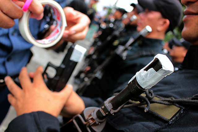 PNP officers submit their service firearms for taping. File photo