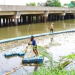Petugas membersihkan sampah yang tertahan di Setu Pangarengan, Depok, Jawa Barat (26/11/2025).