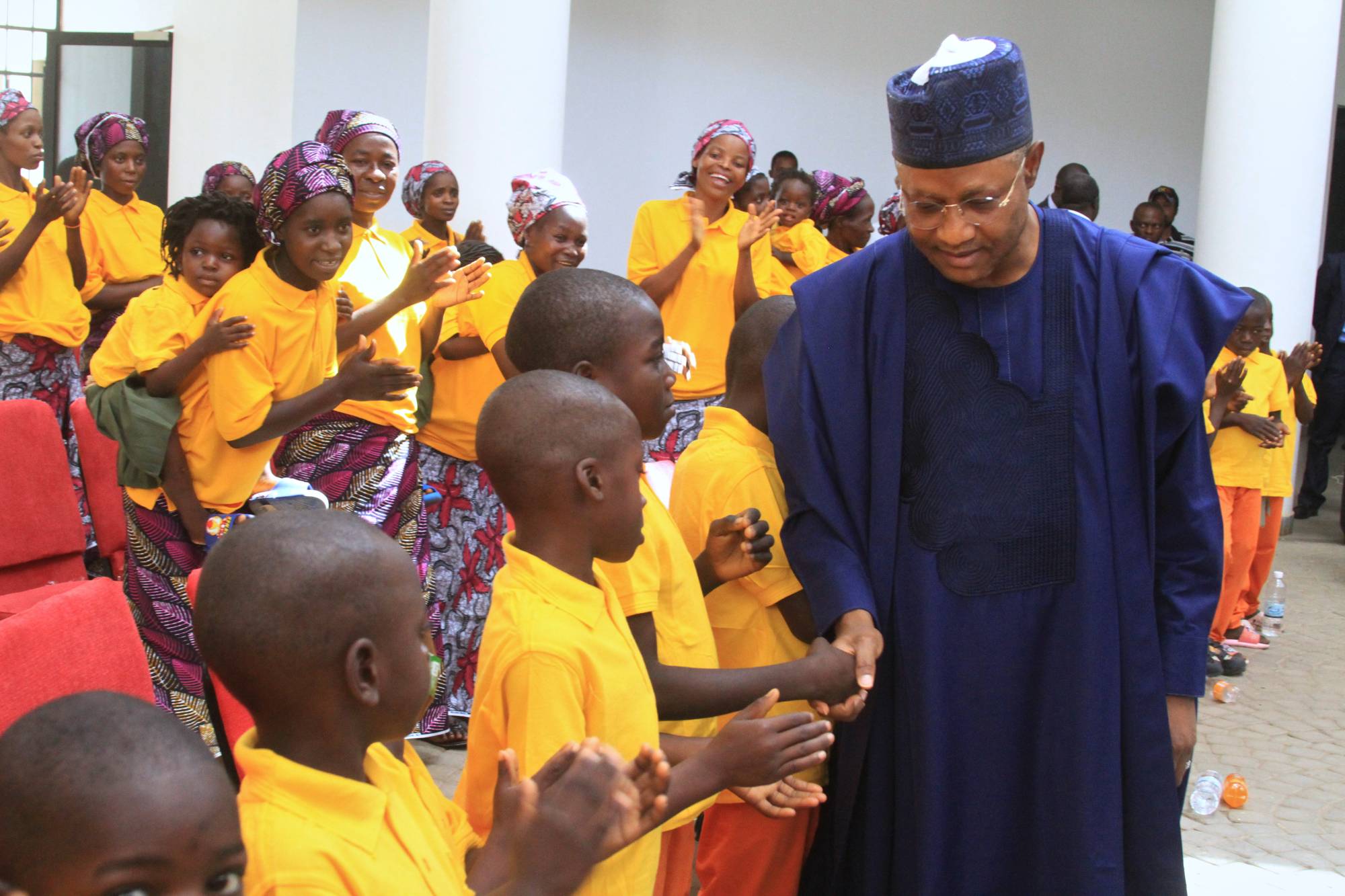 Governor Uba Sani of Kaduna State shaking hands with previously kidnapped church congregants after their return