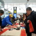 书法家们为旅客送祝福。受访单位供图