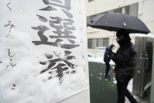 都内でも雪が降り、投票所の看板にも積もっていた=2026年2月8日正午、東京都墨田区、諫山卓弥撮影