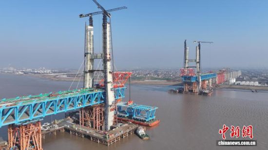 24日，沪渝蓉高铁V标崇启公铁长江大桥主通航孔“首段”钢梁精准架设到位。上海海事局供图