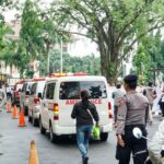 Iring-iringan ambulans memasuki Balai Kota Depok, Senin (9/2/2026). Aksi tersebut menjadi simbol keprihatinan atas banyaknya kepesertaan BPJS Kesehatan warga Depok yang dinonaktifkan.