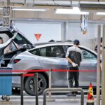 Workers check on Tesla model Y at the Tesla Gigafactory in Sanghai