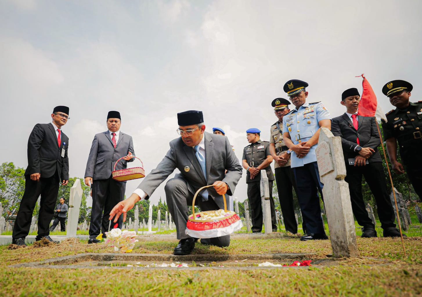Wali Kota Bandung, Muhammad Farhan menaburkan bunga di pusara pahlawan saat ziarah peringatan 80 tahun Bandung Lautan Api di Taman Makam Pahlawan Cikutra, Kamis (23/4). Momen hening ini menjadi pengingat semangat pengorbanan para pejuang terus dilanjutkan untuk menghadapi tantangan kota masa kini.(Dok. Humas Pemkot Bandung)