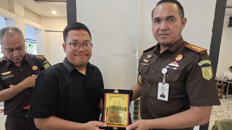 Kajari Medan, Ridwan Sujana Angsar saat menyerahkan cinderamata berupa plakat kepada Forwakum Sumut diwakilkan Sekretaris Ansah Tarigan dalam pertemuan sederhana di Medan.