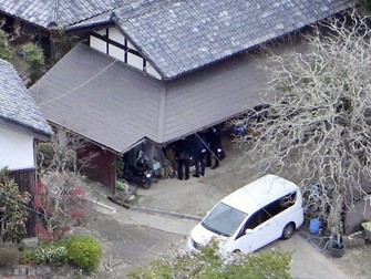 This photo taken from a Kyodo News helicopter shows police investigators searching the house of a missing 11-year-old boy found dead alongside a road in a wooded area in Kyoto Prefecture, on April 15, 2026. (Kyodo)