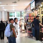 4月11日，两位泰国游客(左一、左二，背着包的男女)正在逛位于重庆市渝中区的新重庆国际小商品批发中心。张旭 摄