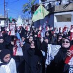 Những người cầm chân dung nhà báo người Lebanon Amal Khalil - người thiệt mạng sau một vụ không kích của Israel - tại thị trấn Bissariye, Sidon ngày 23-4 - Ảnh: AFP