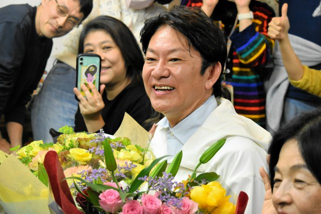 練馬区長選の当選を決め、支持者らと笑顔で写真撮影する吉田健一氏=2026年4月12日午後11時43分、東京都練馬区、木佐貫将司撮影