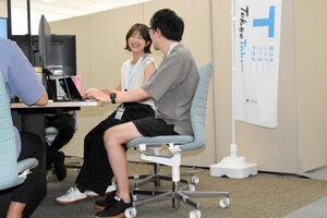 クールビズが始まり、Tシャツや短パン姿で仕事をする東京都の職員たち=2026年4月22日、東京都庁