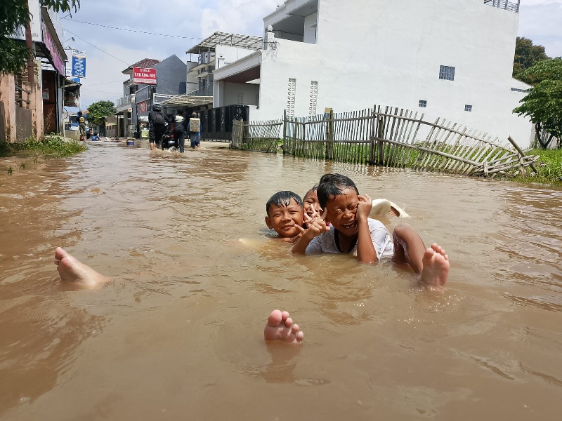 Anak anak bermain di air banjir yang menggenang Kawasan Baleendah. (eko sutrisno/radar badnung)