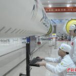 在上海航天设备制造总厂的总装厂房里，操作人员在火箭贮箱旁查询数据信息。(上海航天设备制造总厂 供图)