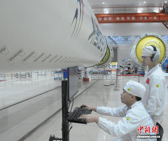 在上海航天设备制造总厂的总装厂房里，操作人员在火箭贮箱旁查询数据信息。(上海航天设备制造总厂 供图)