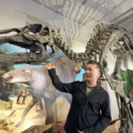 北海道大学総合博物館で新たに展示が始まったむかわ竜の全身骨格について説明する小林快次教授（浜本道夫撮影）